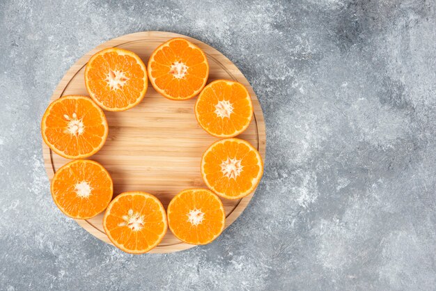 Нарезанные сочные свежие апельсиновые фрукты в деревянной тарелке.