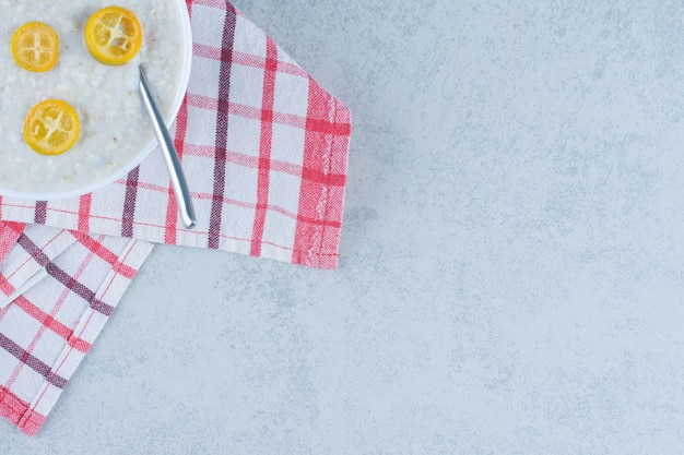 Sliced lemon on plate of rice on marble.