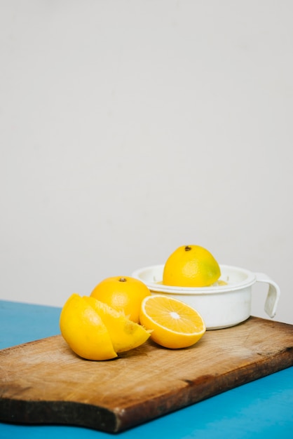 Free photo sliced lime juice with manual juicer on chopping board