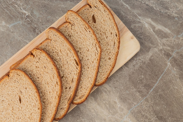 Una pagnotta di pane integrale a fette su una superficie di pietra