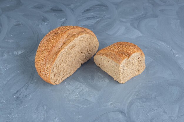 Sliced lumps of sesame covered bread on marble background. 
