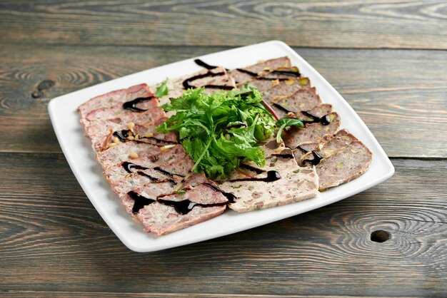 로컬 레스토랑 copyspace 음식 먹는 전채 구운 진미 미식가 배고픈 식욕 개념에서 나무 테이블에 채소와 소스로 장식 된 슬라이스 고기 접시.
