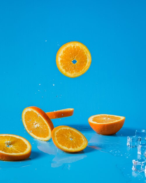 Sliced orange falling over ice cubes