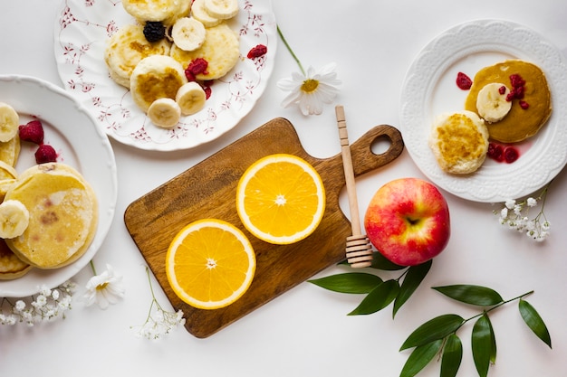 Sliced oranges with pancakes and fruits