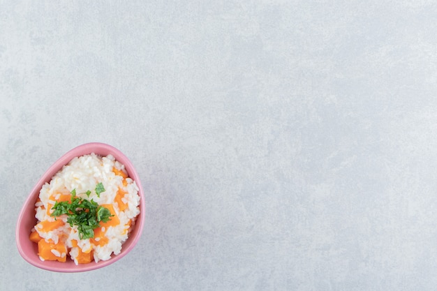 Sliced parsley and carrot rice in the bowl , on the marble background.