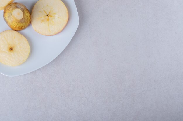 Sliced pears on a plate on marble table.