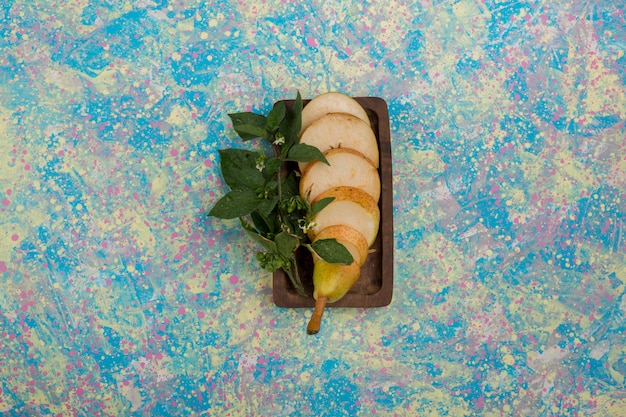 Free photo sliced pears served with mint leaves on a wooden platter in the center