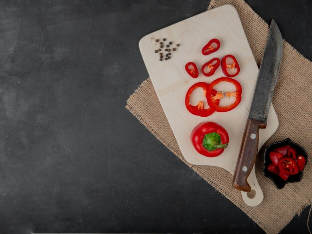 sliced pepper and black pepper on cutting board with knife