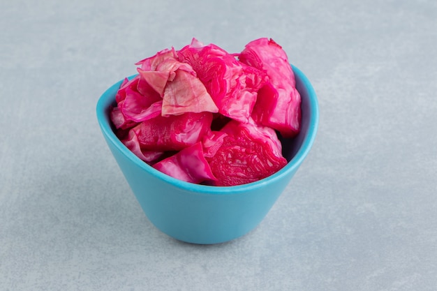 Sliced picked purple cabbage in bowl on the marble surface