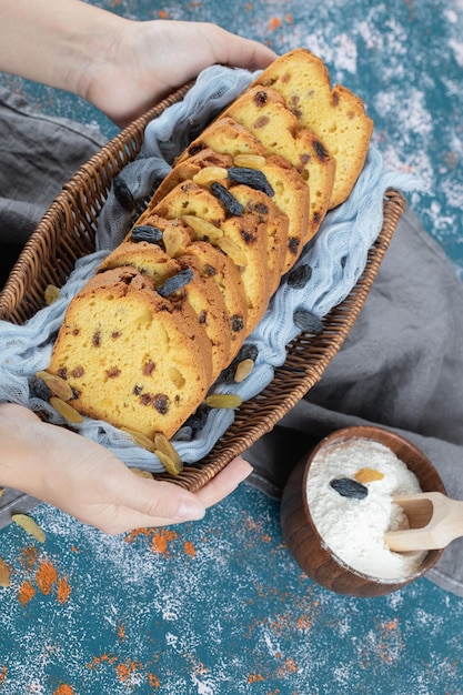 Torta affettata sull'asciugamano blu sul canestro di legno.