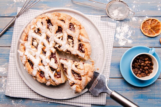 Sliced pie with coffee beans and dried citrus