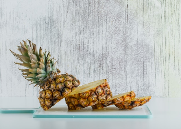 Foto gratuita ananas affettato con tagliere