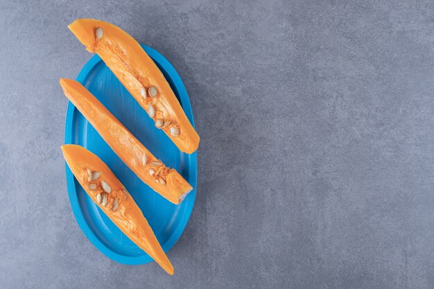 A sliced of pumpkin, on the tray , on the marble surface.