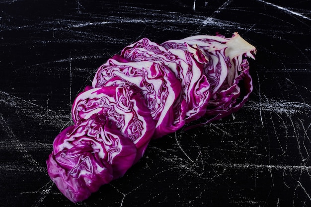 Sliced purple cabbage on a black