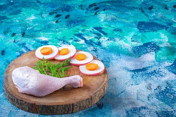 Free Photo sliced radish and carrots with dill and chicken drumstick on a board
