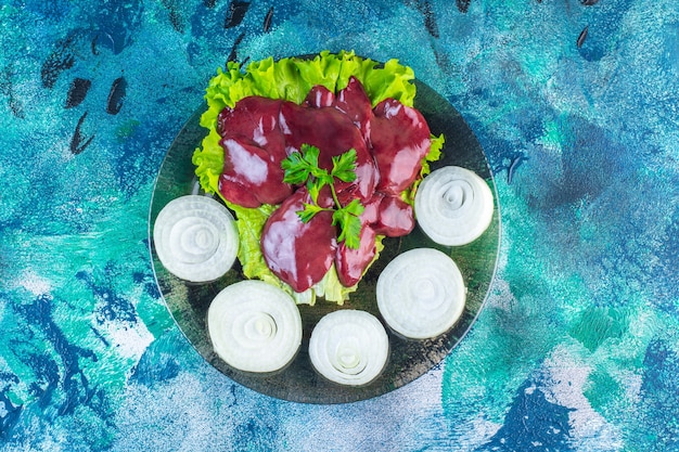 Ravanello e frattaglie affettate su una foglia di lattuga sul piatto, sullo sfondo blu
