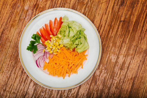 Sliced raw food on plate on wooden surface