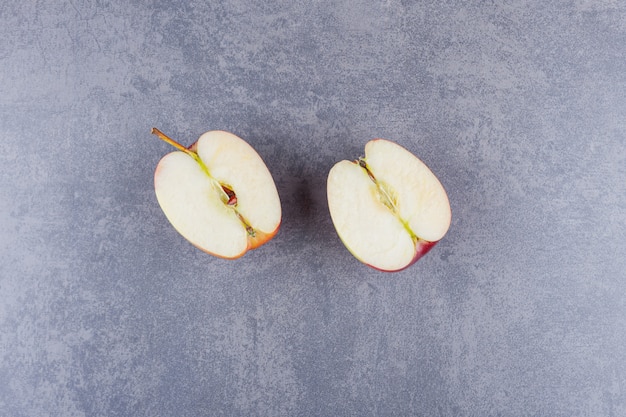 Foto gratuita mela rossa a fette di frutta posta su un tavolo di pietra.