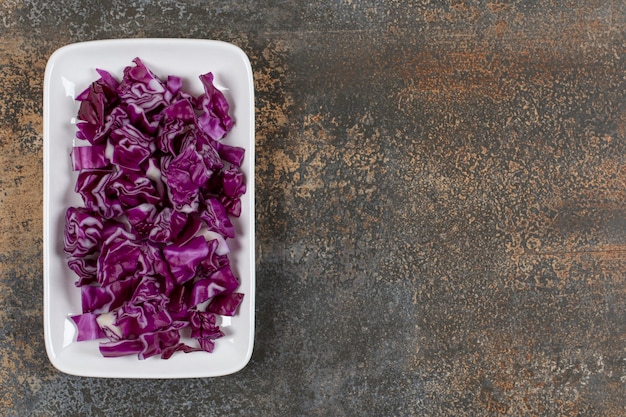 Sliced red cabbage in the bowl, on the marble surface