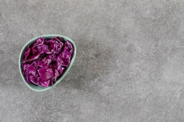 Sliced red cabbage in a bowl, on the marble table. 