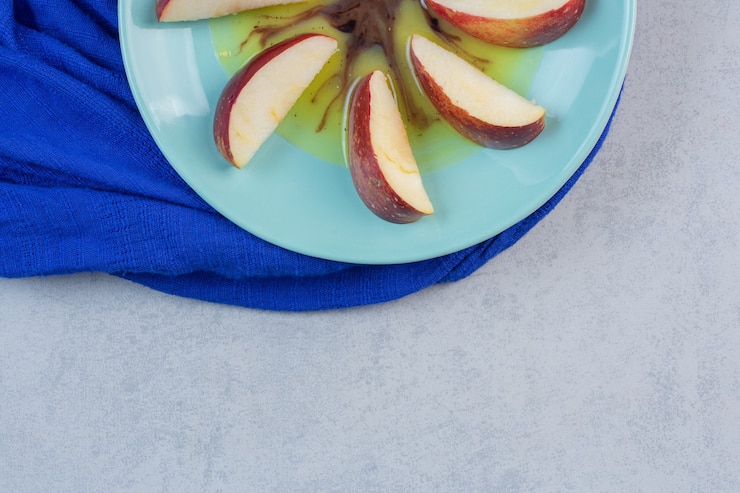 Free Photo sliced red yellow apples in blue plate .
