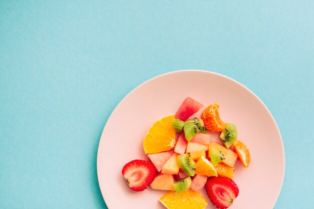 Sliced ripe appetizing tropical fruits on plate