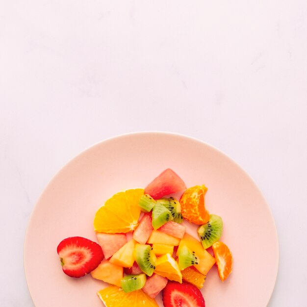 Нарезанные спелые свежие тропические фрукты на тарелке