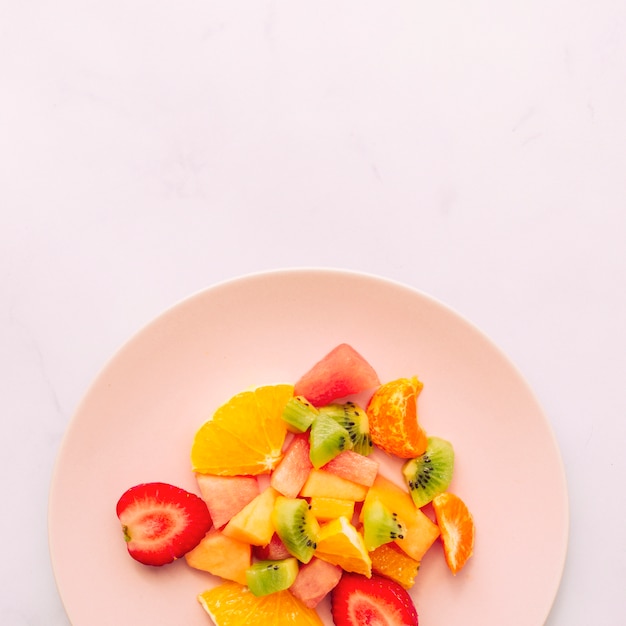 Sliced ripe fresh tropical fruits on plate