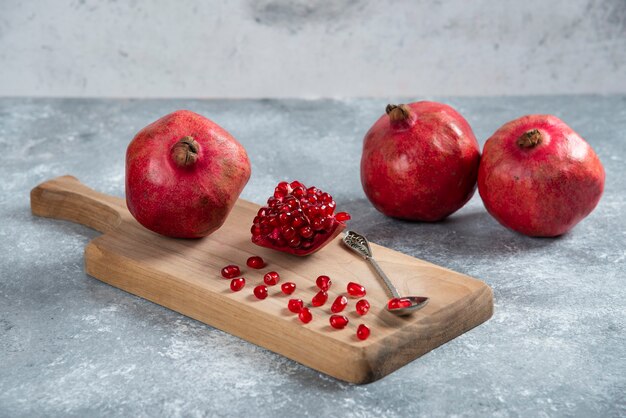 Sliced ripe pomegranate on a wooden board.