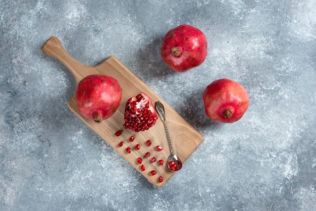 Sliced ripe pomegranate on a wooden board.