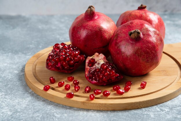 Sliced ripe pomegranate on a wooden board.