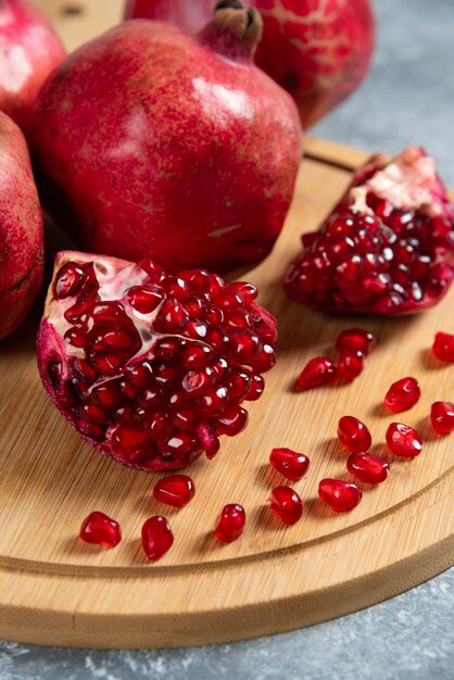 Sliced ripe pomegranate on a wooden board.