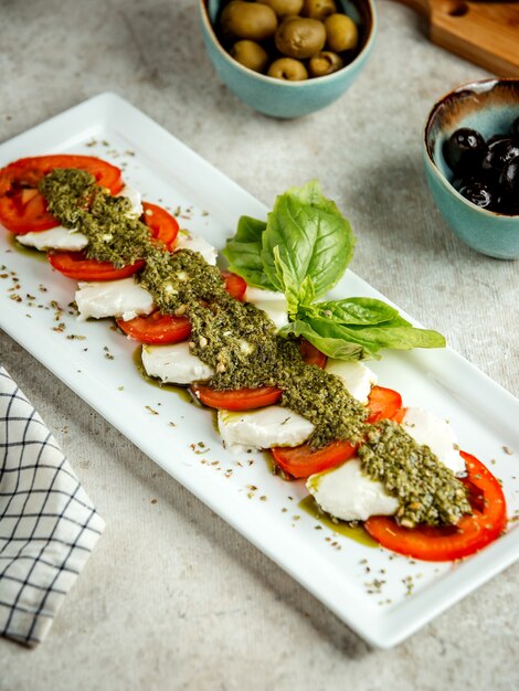 Sliced tomato and cheese with herbs