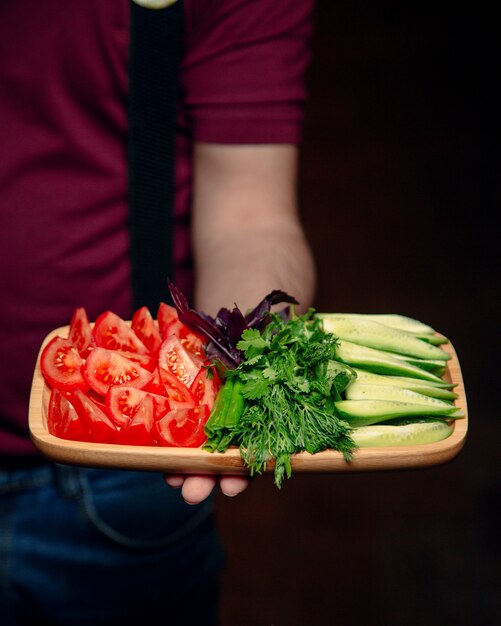 Sliced tomato and cucumber with greenery