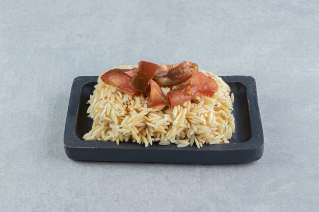 Sliced tomatoes on the rice wooden plate , on the marble.