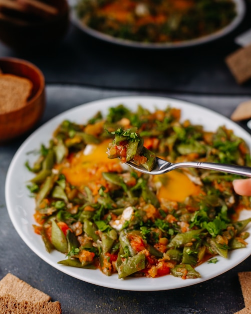 썰어 야채 식사 회색에 흰색 접시 안에 빵 덩어리 계란과 함께 다채로운 야채 식사 튀김