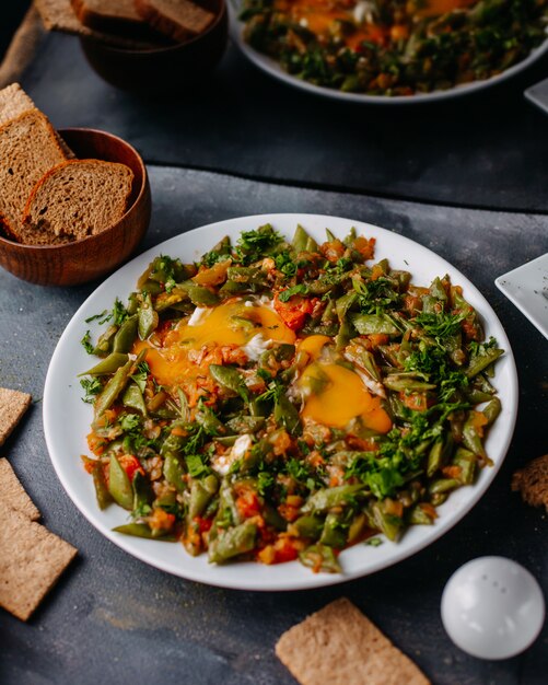 sliced vegetable meal fried colorful vegetables meal along wtih bread loafs eggs inside white plate on grey