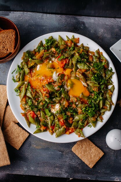 スライスした野菜の食事はカラフルな野菜の食事をパンに沿って揚げたパンの卵は灰色の白いプレート内にローフします