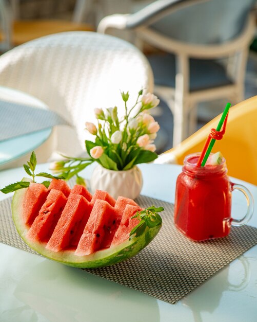 Sliced watermelon and a glass with watermelon juices