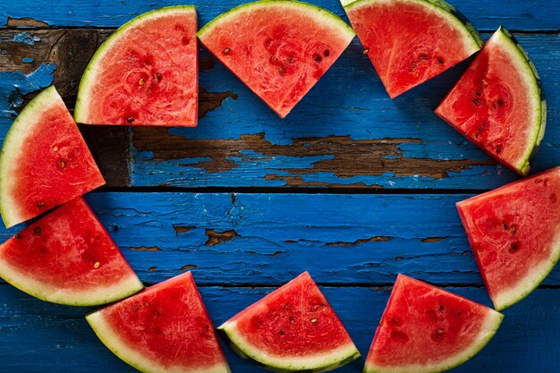 Free photo sliced watermelon top view. many slices on an old rustic blue table. side composition with copy space. food backrgound.