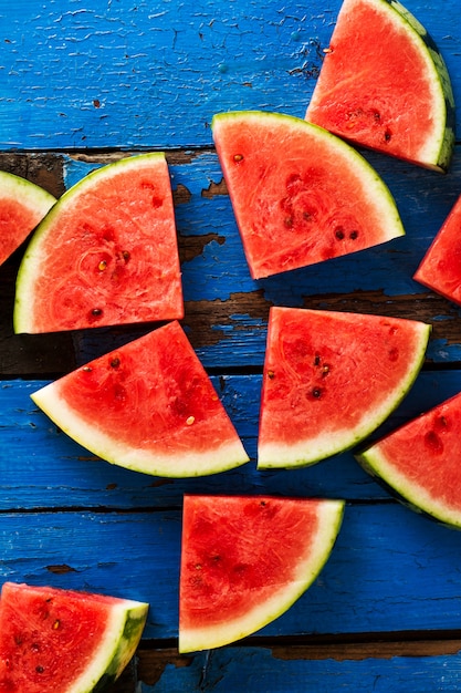 Sliced watermelon Top View. Many slices on an old rustic blue table. Side composition with copy space. Food Backrgound.