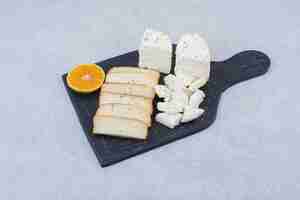 Бесплатное фото Нарезанный белый хлеб с ломтиком апельсина на разделочной доске. фото высокого качества