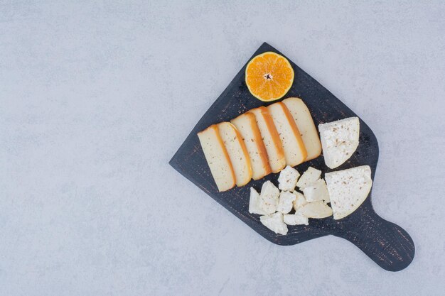 Sliced white bread with slice of orange on cutting board. High quality photo