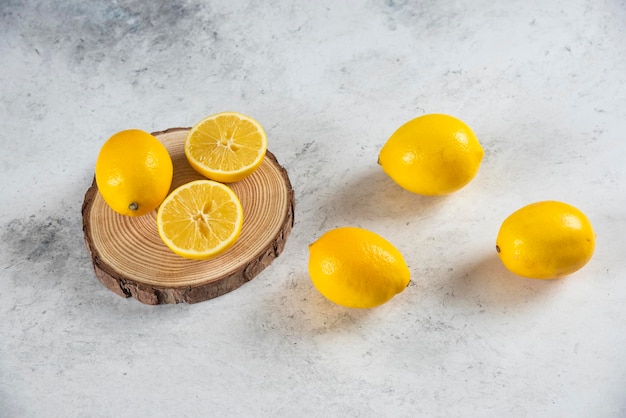 Sliced and whole lemon on a marble background.