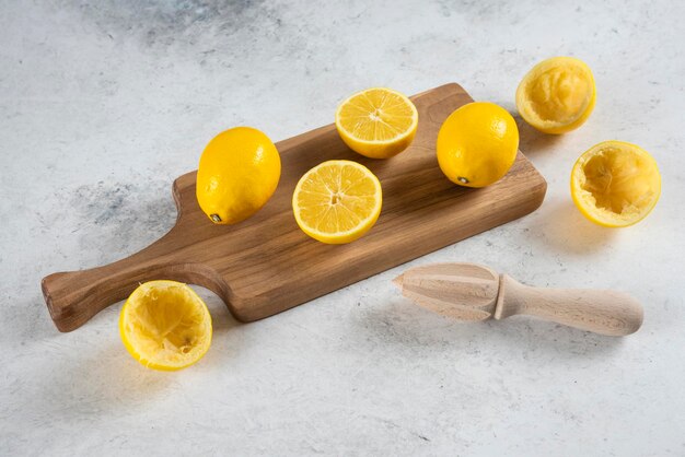 Sliced and whole lemons with wooden reamer .