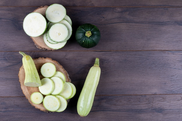 Sliced zucchinis on stubs and dark wooden table. top view