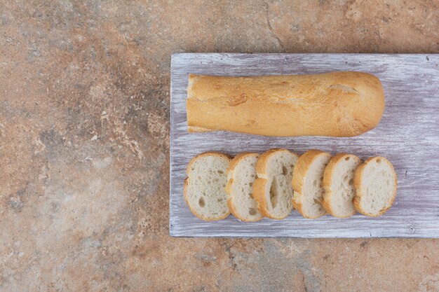 Slices of baguette bread on wooden board