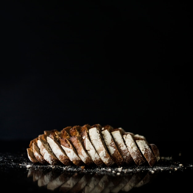 Slices of baked bread against black background