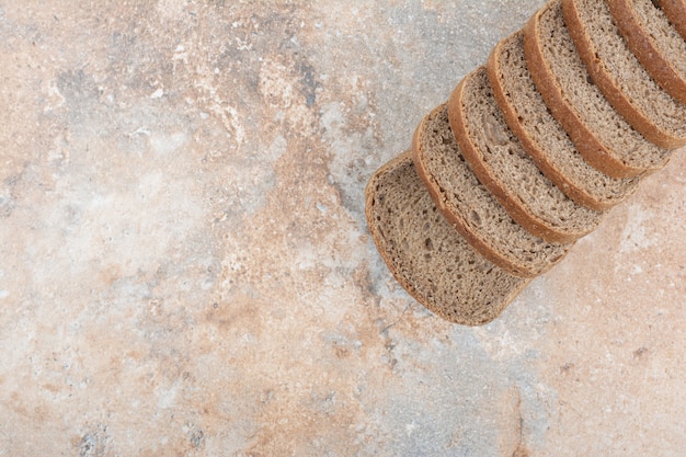 Slices of black bread on marble background