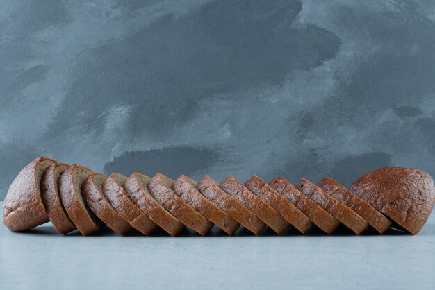 Slices of black bread on stone surface